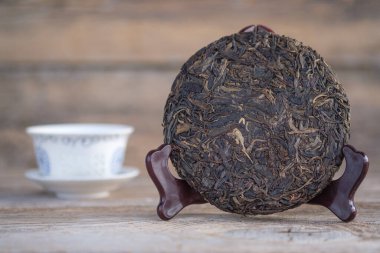Ahşap tezgahta geleneksel Çin pu-erh çayı. Krep şeklinde mayalanmış çiğ çay.