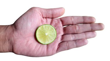 Beyaz arka planda izole edilmiş insan avucunda taze kireç dilimi Citrus aurantiifolia sağlıklı yaşam tarzı için makro fotoğrafçılık, detoks diyeti, C vitamini ve organik gıda pazarlama kavramı..