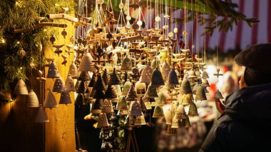 Karmaşık mavi desenli el yapımı seramik çanlar Noel pazarında sıcak ışıkta asılı duruyor. Şenlik dekorasyonu, el sanatları ve bu sezonun ilham perisi için mükemmel..