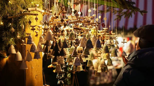 Karmaşık mavi desenli el yapımı seramik çanlar Noel pazarında sıcak ışıkta asılı duruyor. Şenlik dekorasyonu, el sanatları ve bu sezonun ilham perisi için mükemmel..