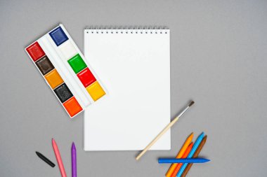 Gri bir arkaplanda tebeşirler ve boyalar.