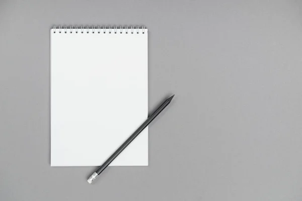 A notepad whit pencil and drafts on a gray background — 图库照片