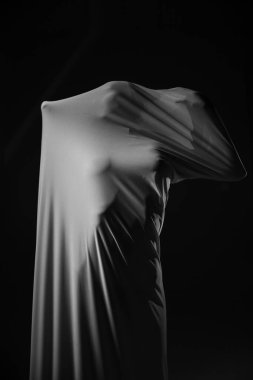 Siyah arka planda kumaş içinde poz veren bir kız