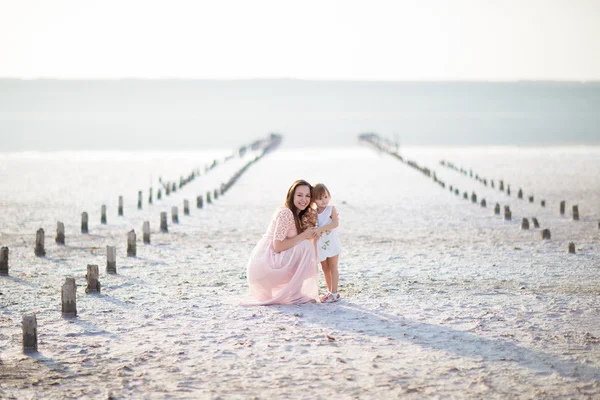 Mor dotter flicka kvinna barn Sit sand vit vatten kärlek familj — Stockfoto