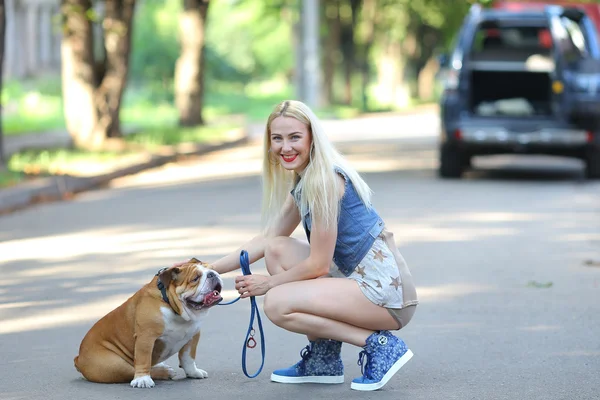 Junge schöne Frau Mädchen Dame blonde Haare mit roten Lippen in lässigem Stil amerikanische Bulldogge. — Stockfoto