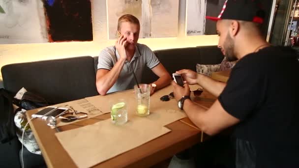 Мужчины друзья в кафе говорят обсудить с технологией планшет телефона — стоковое видео