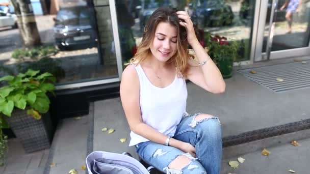 Young woman on the floor on the street looking in camera using p — Stock Video