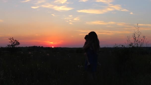 Junge Mutter hält ein Kind gegen die Sonne — Stockvideo