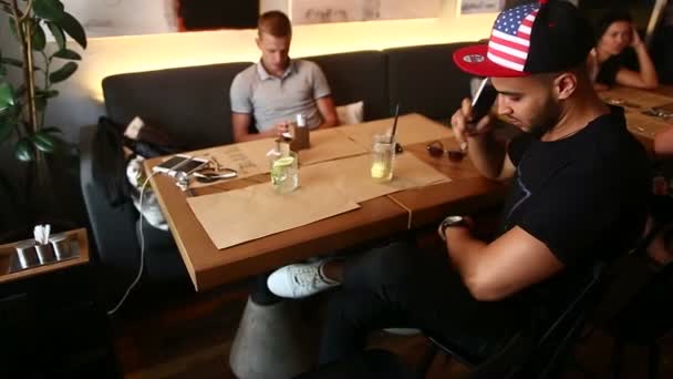 Mannelijke vrienden in café gesprek bespreken met technologie telefoon tablet — Stockvideo