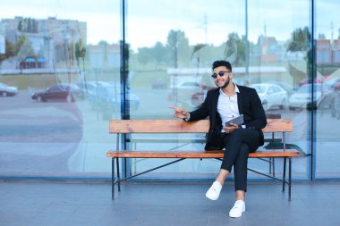 Güneş gözlüğü iş yakınındaki tablet ile Arapça koyar takım elbiseli adam