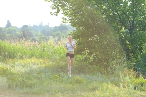 Joven hermosa mujer corriendo muestra entrenamiento de entrenamiento de estómago de prensa usando top . — Foto de Stock