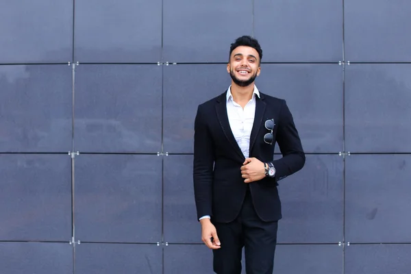 Арабська хлопець у бізнес-центрі стоїть, посміхаючись, ходьба повільно — стокове фото