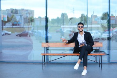 Güneş gözlüğü iş yakınındaki tablet ile Arapça koyar takım elbiseli adam