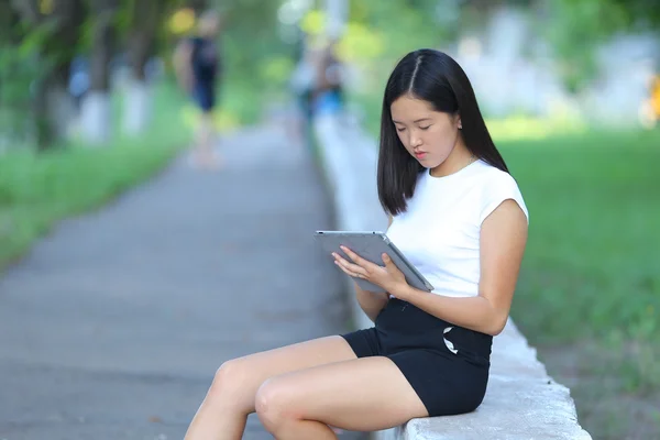 Chica joven en el parque de aprendizaje con la tableta — Foto de Stock