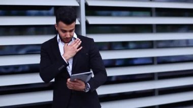 Arapça iş yakınındaki tablet ile başparmak aşağı gösterir takım elbiseli adam