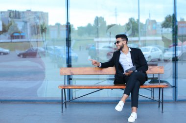 Güneş gözlüğü iş yakınındaki tablet ile Arapça koyar takım elbiseli adam