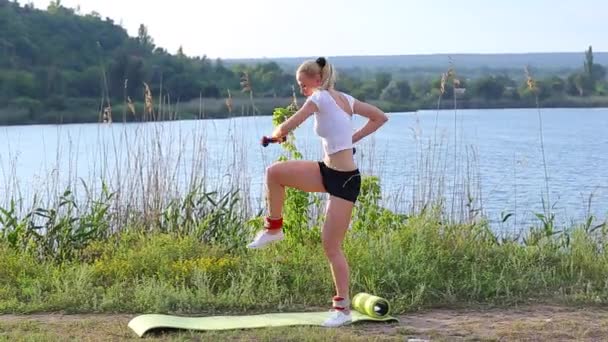 Vrouwelijke atleet squats gewogen arm benen training outdors — Stockvideo