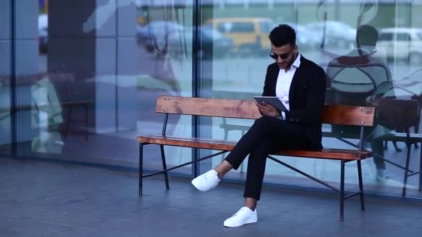 Hombre de traje árabe con la tableta cerca de negocios — Vídeos de Stock