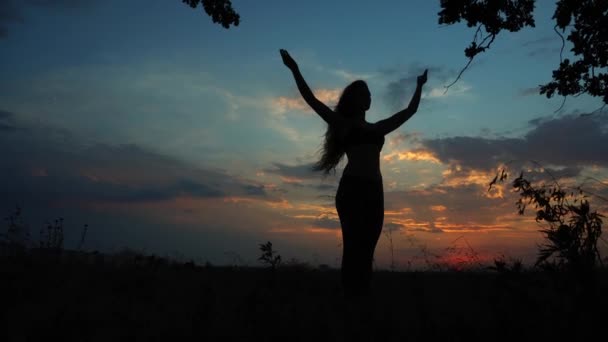 Sziluettjét női lány csinálás jóga háttér vörös naplemente ég — Stock videók