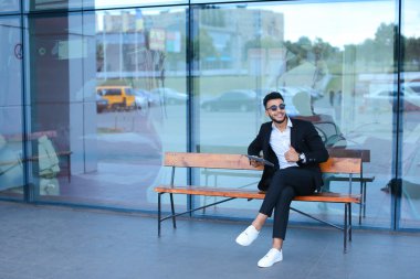 Güneş gözlüğü iş yakınındaki tablet ile Arapça koyar takım elbiseli adam