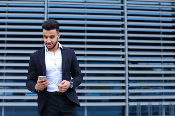 Genç Arap adam kullanır mobil akıllı telefon İş Merkezi