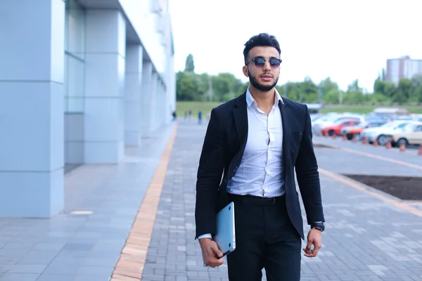 Árabe chico en negocios centro stands sonriendo caminar lento — Foto de Stock
