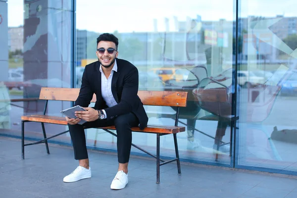 Man in suit arabic puts on sunglasses with tablet near business — Stock Photo, Image