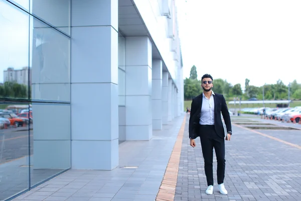 Árabe chico en negocios centro stands sonriendo caminar lento — Foto de Stock