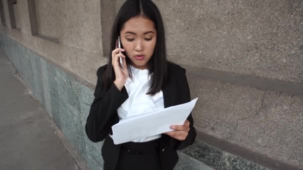 Jonge mooie zakelijke vrouw vrouwelijke meisje portret Talk over telefoongesprek bezit zijn van documenten op de achtergrond kantoorgebouw buiten — Stockvideo