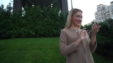 Genç sarışın güzel kız iletişim basın kullanım hücresel Apps akıllı telefon yeşil bitki arka plan