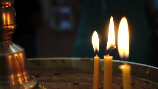 Chamas quentes de três velas isoladas no fundo preto quarto escuro — Vídeo de Stock