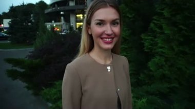 Şehirde akşam yürüyüş gülümseyen genç güzel sarışın kadın portre