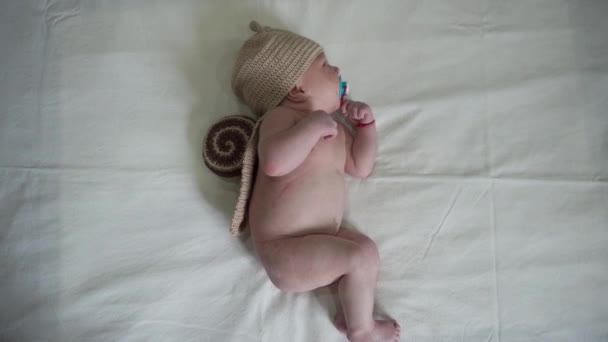新生児・乳児の子供が毛布に滑稽な服で横たわってください。 — ストック動画