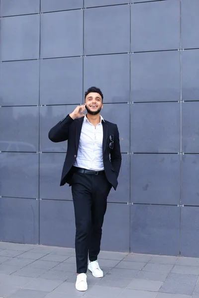 Hombre árabe guapo habla en el teléfono inteligente en el centro de negocios — Foto de Stock