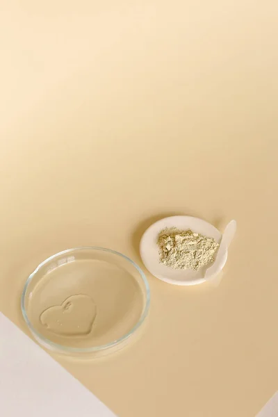 Порошок из глины и вода в стеклянной банке на светлом фоне с копировальным пространством. — стоковое фото