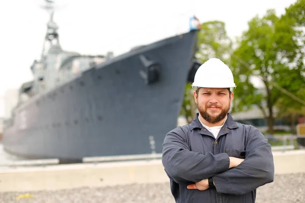 Portrait of marine captain standing near big vessel in background.