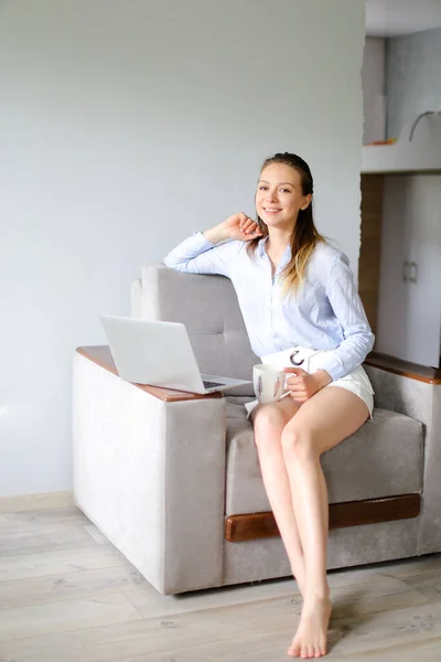 Joven mujer de negocios trabajando con el ordenador portátil en casa y beber café. — Foto de Stock