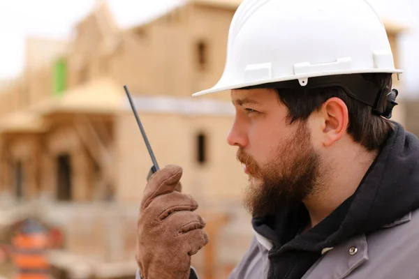 Retrato de construtor falando por walkie talkie no canteiro de obras. — Fotografia de Stock