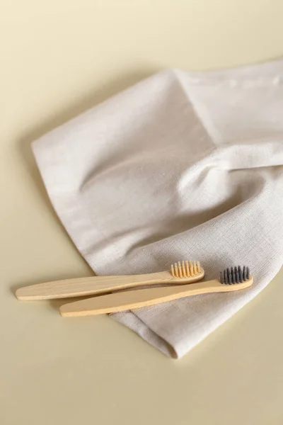 Two ecological wooden toothbrushes lying on white towel. — Stock Photo, Image