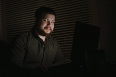 Euroepean erkek bilgisayar korsanı geceleri dizüstü bilgisayarla çalışıyor.