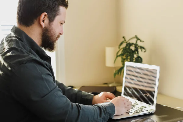 Joven hombre de negocios que trabaja en la oficina, mirando la pantalla del ordenador portátil. — Foto de Stock