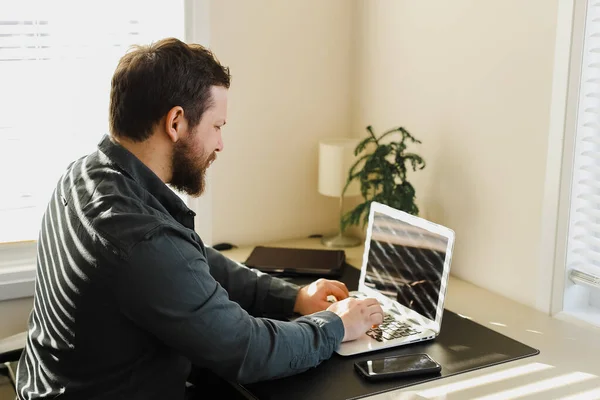 Gerenciador masculino trabalhando no escritório, olhando para a tela do computador portátil. — Fotografia de Stock