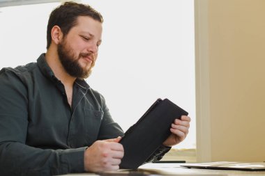 Ofiste tablet kullanarak erkek yöneticiyi kapat.