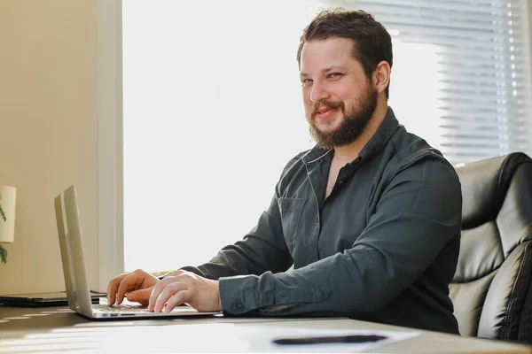 Masculino gerente sentado na mesa de escritório trabalhando no computador portátil. — Fotografia de Stock