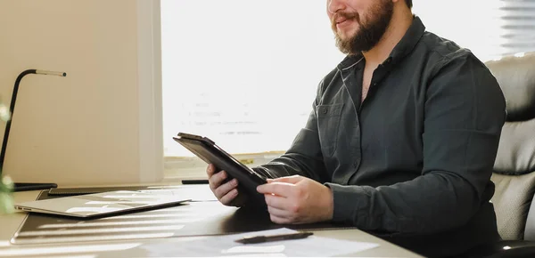 Diretor de negócios masculino usando tablet no escritório, laptop na mesa. — Fotografia de Stock