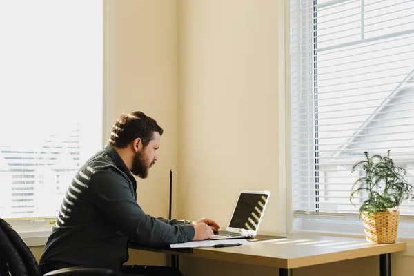 남자 관리자 책상에 앉아서 캐비닛에서 노트북을 사용하는 모습. — 스톡 사진