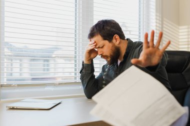 Erkek işadamı evrakları ofise atıyor.