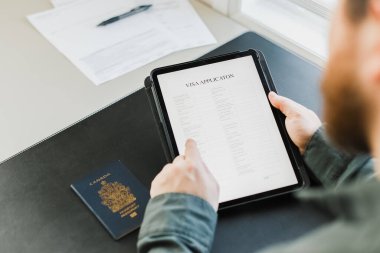 Vize alan ve başvuru formunu tablete, pasaportunu masaya koyan adamı kapat..