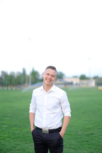 Young boy standing on football field and wearing white shirt. — Stock Photo, Image