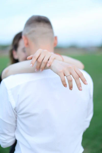 BFocus στο δαχτυλίδι, πίσω όψη άντρας αγκαλιάζει γυναίκα έξω. — Φωτογραφία Αρχείου